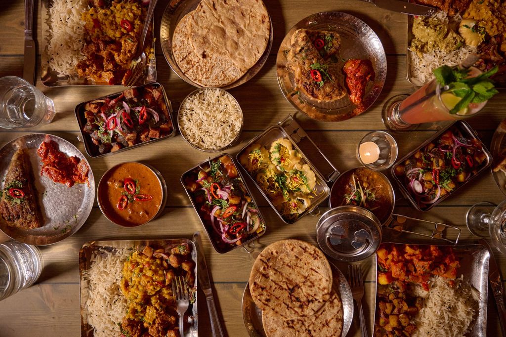 Indian street food Brighton overhead shot on a table with tiffins filled with Indian street food.