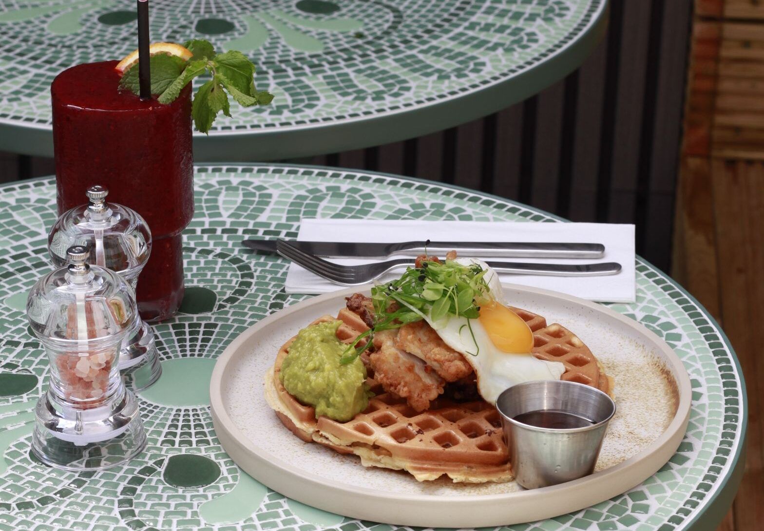 waffle with egg and guacample on the top served with bloody mary