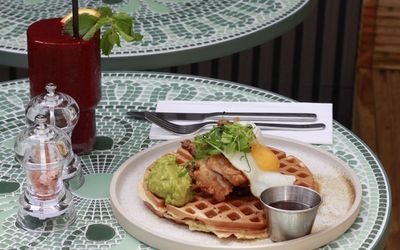 waffle with egg and guacample on the top served with bloody mary