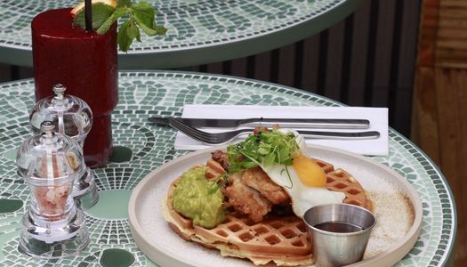 waffle with egg and guacample on the top served with bloody mary