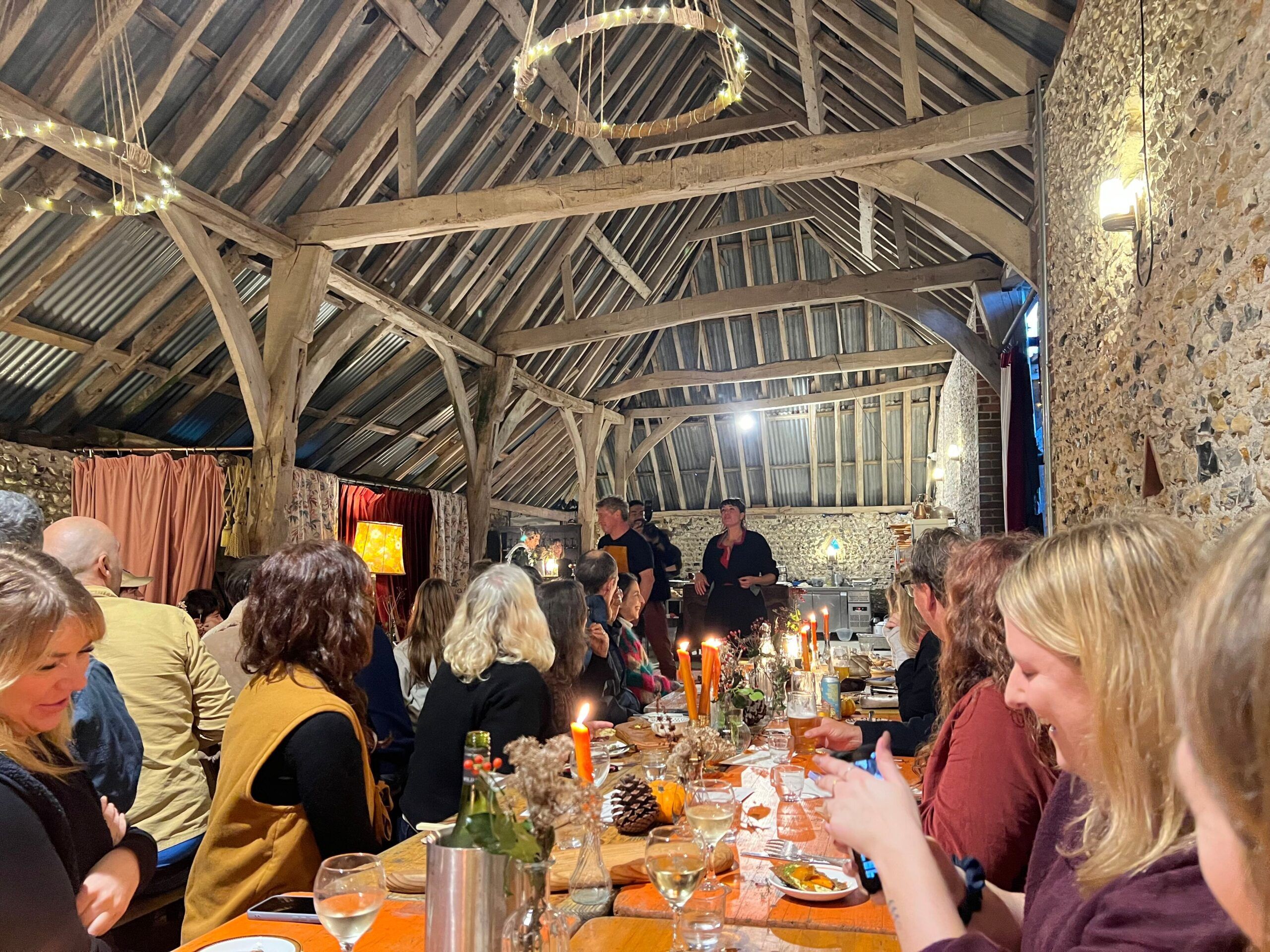people sitting in the barn during woodfire feast