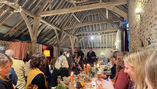 people sitting in the barn during woodfire feast