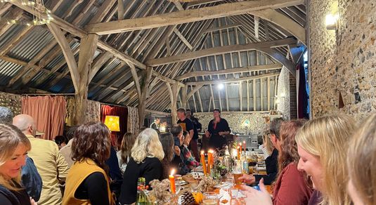 people sitting in the barn during woodfire feast