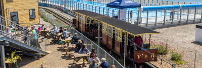 The Volks railway runs through the site where swimmers enjoy the opening day of Sea Lanes - the UK's first National Open Water Swimming Centre . At the heart of Sea Lanes Brighton is a 50m 6 lane outdoor pool located on the beach with local fitness, wellbeing, food, and beverage businesses creating a hub of units from sun up to sundown on the seafront in Kemp Town, Brighton ***Pic by David McHugh / Brighton Pictures 07768 721637***