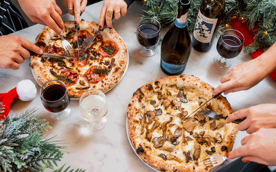 Pizzas with festive foliage and Christmas decorations with wine