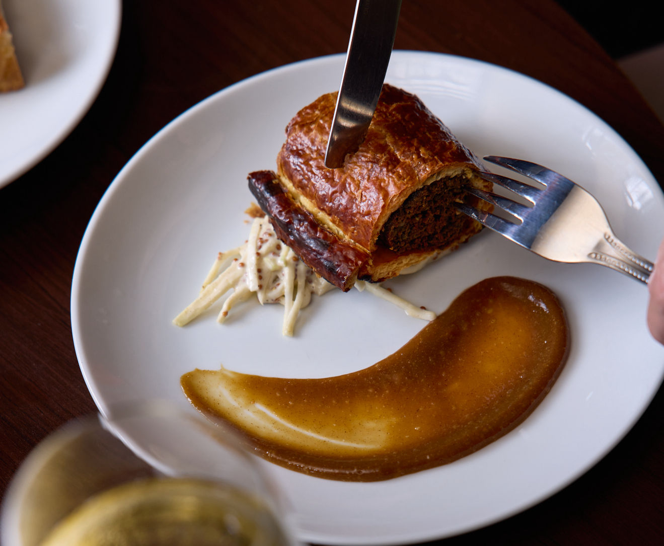 Sausage roll with dip, on white plate