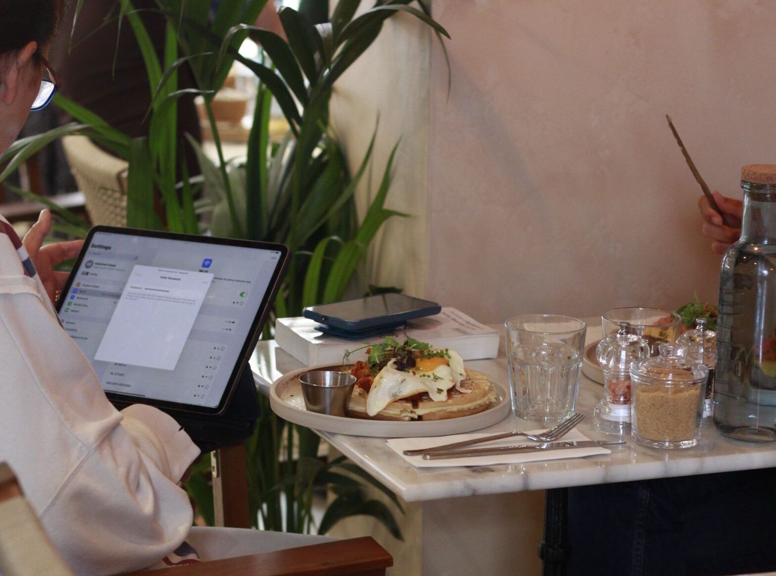 lady on the laptop by the table at A Table