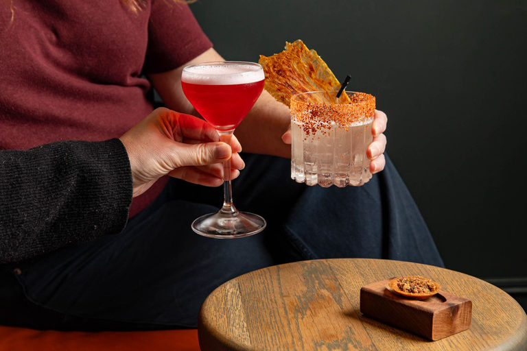 Two people holding cocktails