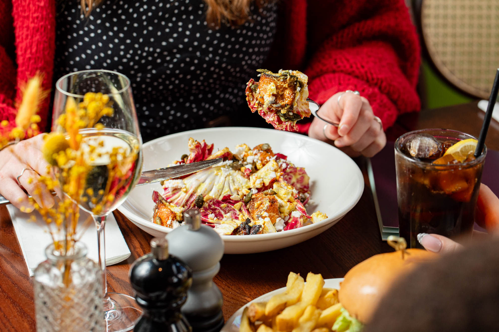 a person eating a meal with glass of wine at The North Star