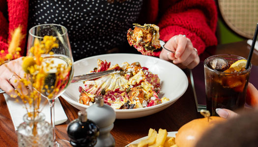 a person eating a meal with glass of wine at The North Star