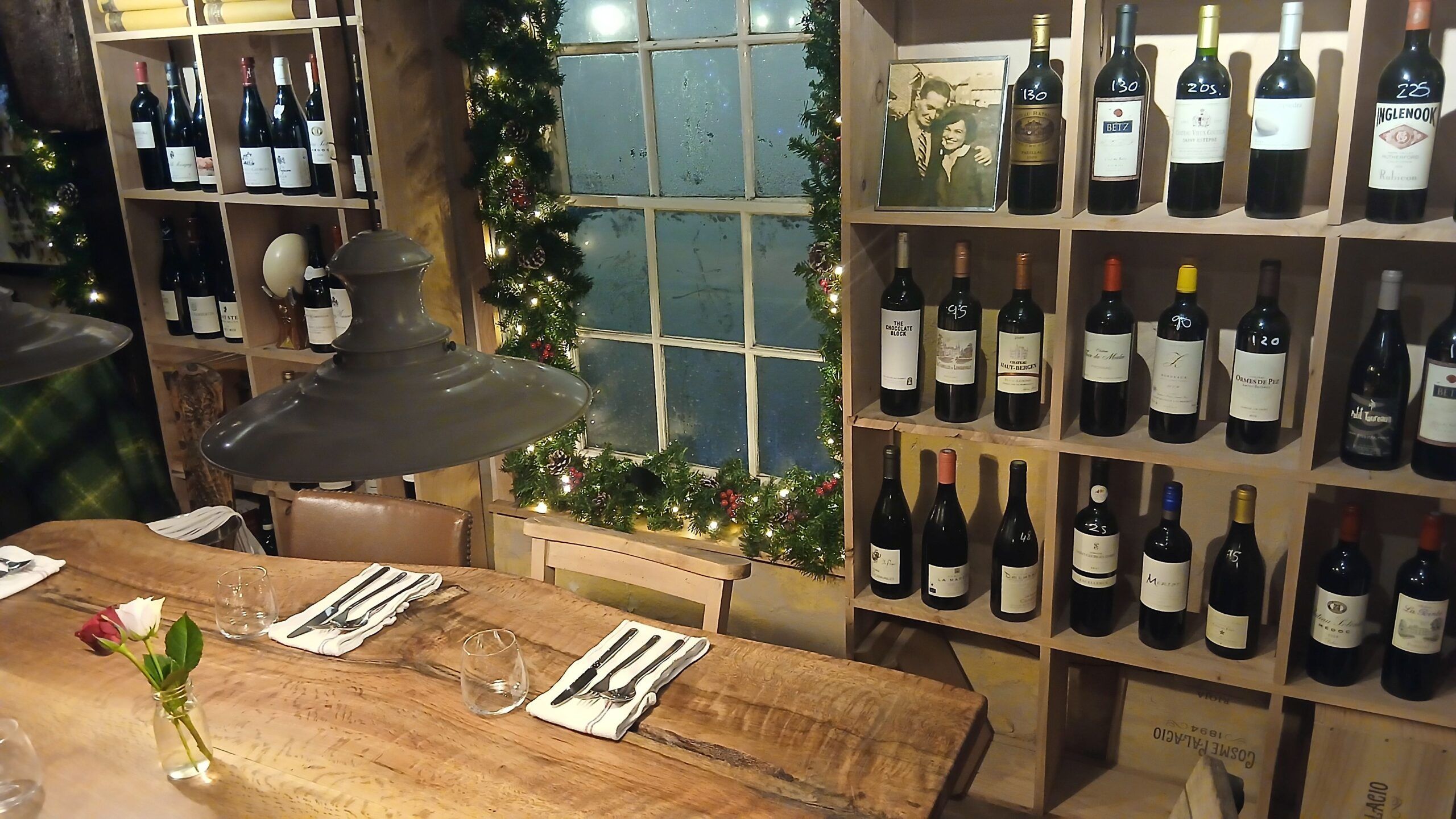 wooden table with the wooden shelves with wine and christmas decoration