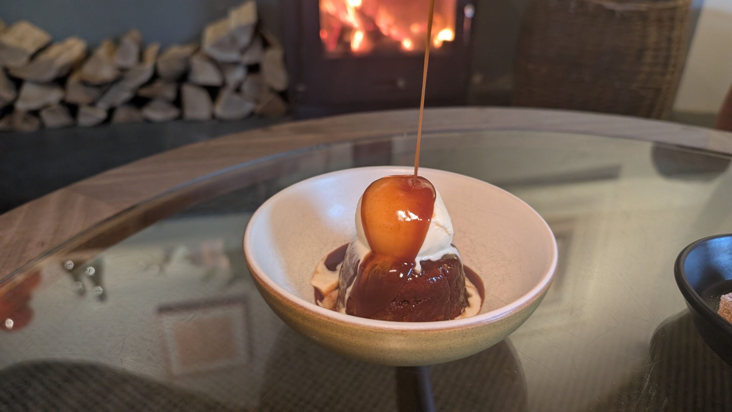 pouring chocolate over the brownie and ice cream