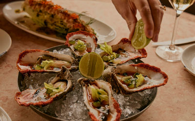 Tray of oysters at The Salt Room, person squeezing lemon