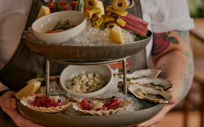 2 layers of fresh seafood being carried by a waiter
