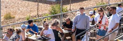 a picture from above at Sea Lanes Brighton. Diners sitting on pic nic benches, close to the pebbles at Sea Lanes Brighton
