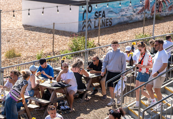 a picture from above at Sea Lanes Brighton. Diners sitting on pic nic benches, close to the pebbles at Sea Lanes Brighton
