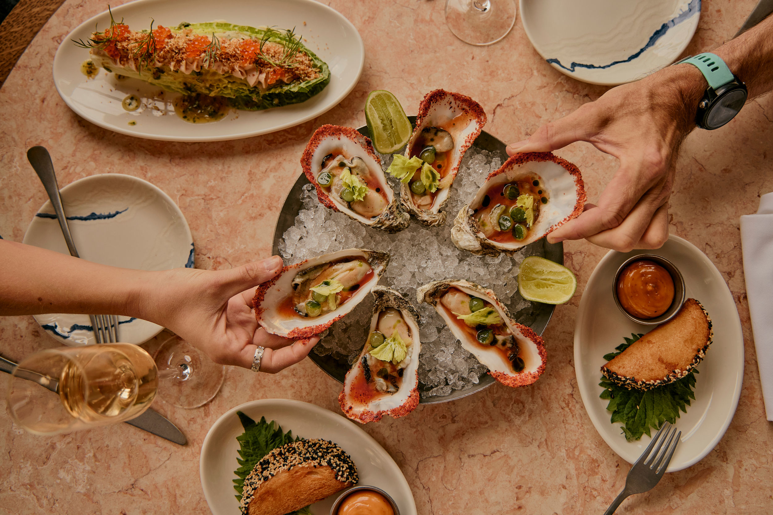 hands choosing oysters. Sharing oysters at The Salt Room