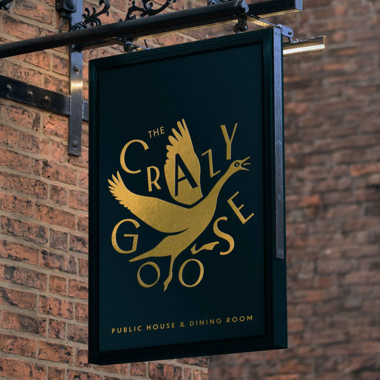 Black and gold sign. The Crazy Goose pub which opens in January 2026. Part of the Black Rock Restaurants Group.
