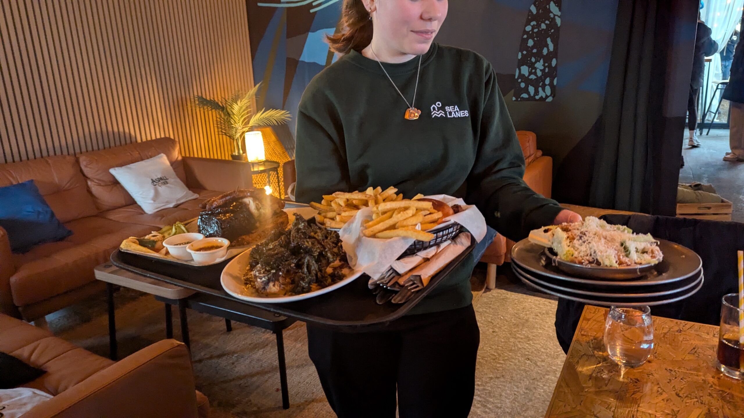 lady bringing mix grill dishes on the table