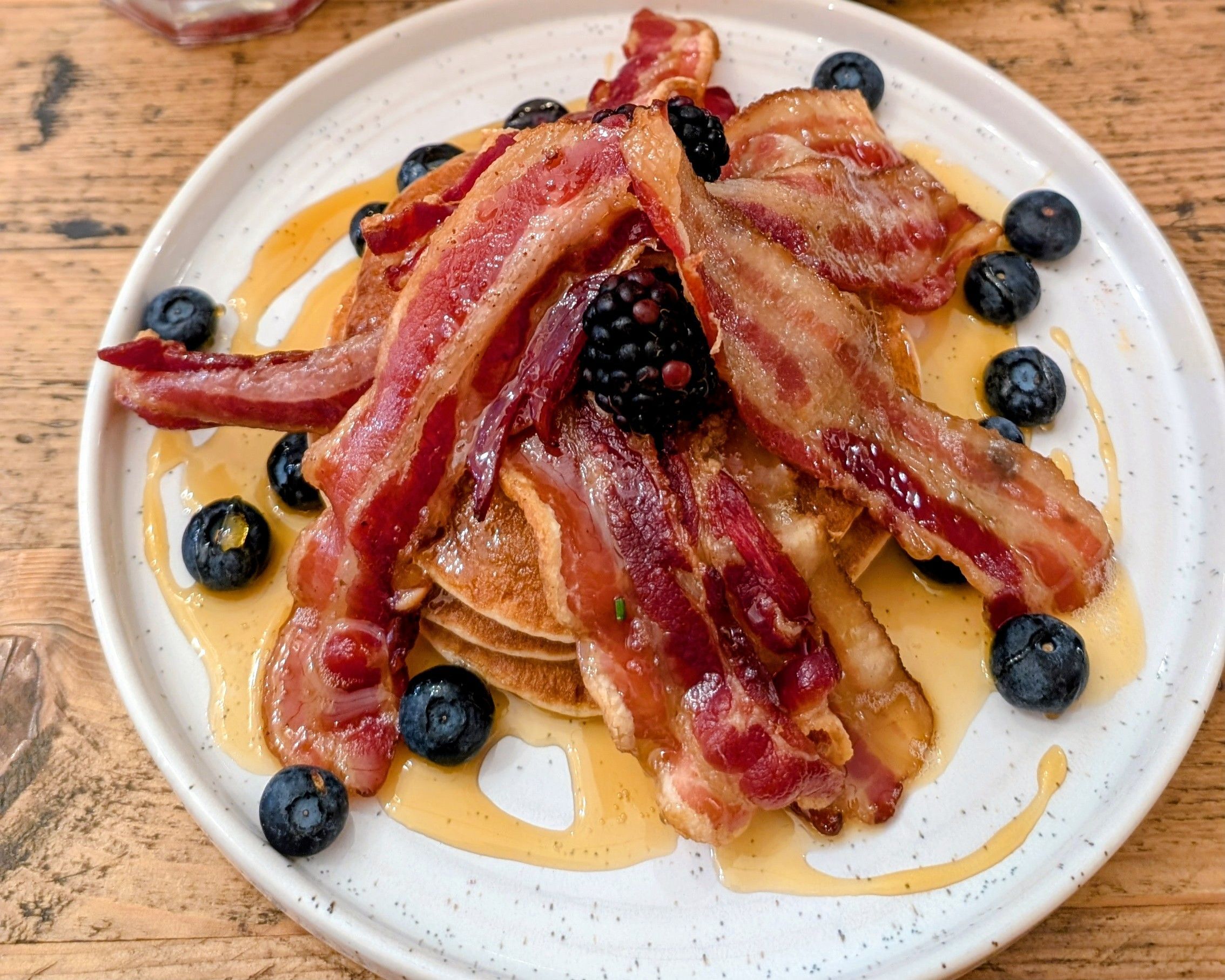 delicious pancakes with bacon, maple syrup and berries