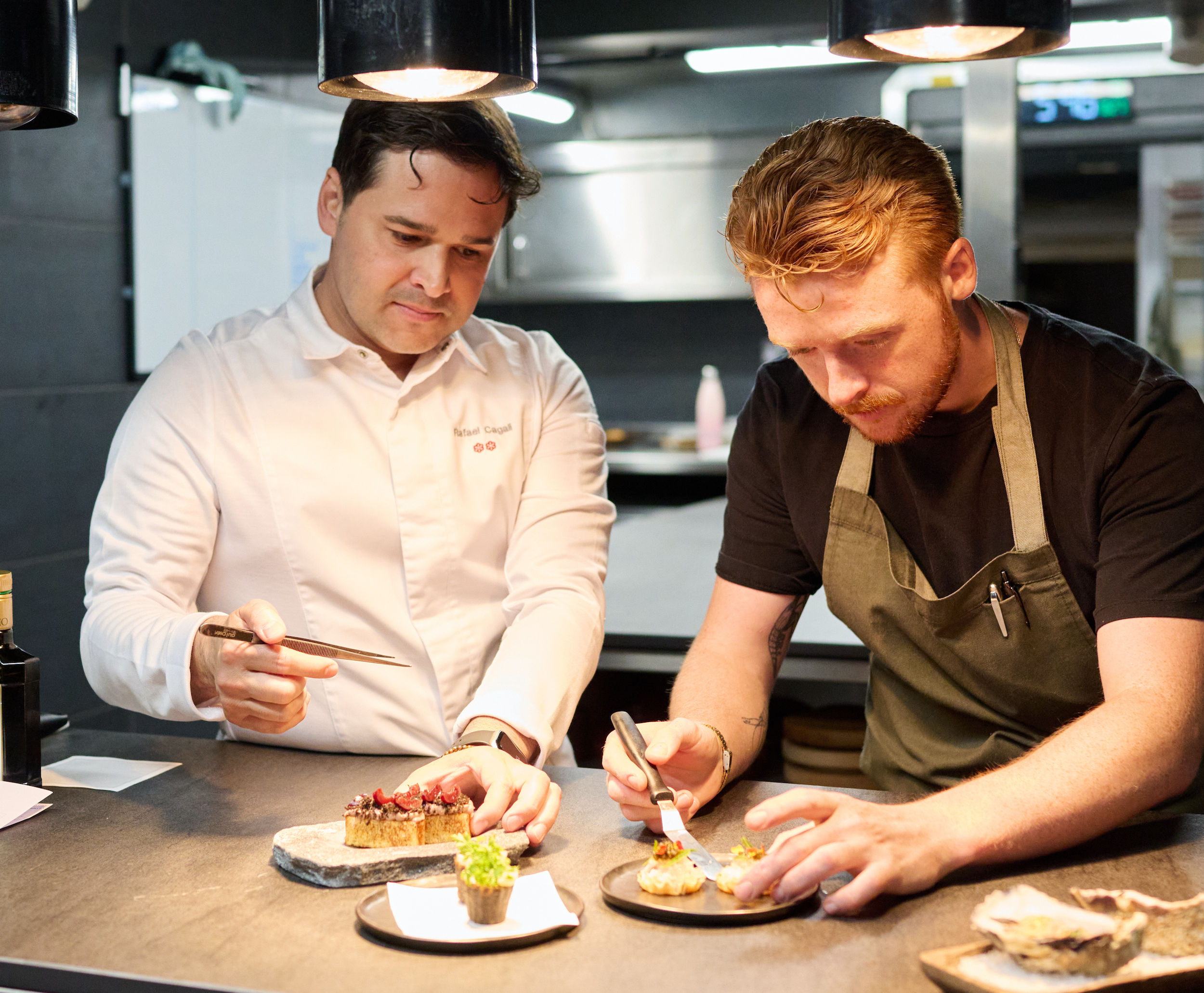 Rafael Cagali and Ewan Waller at the pass plating a dish up at Marè restaurant in Hove. Michelin star chefs in Brighton at the pass. Using absolute precision when plating up the food. Rafael is in chefs whites