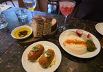 three startes on the table including croquettes, bread, olive oil, hummous