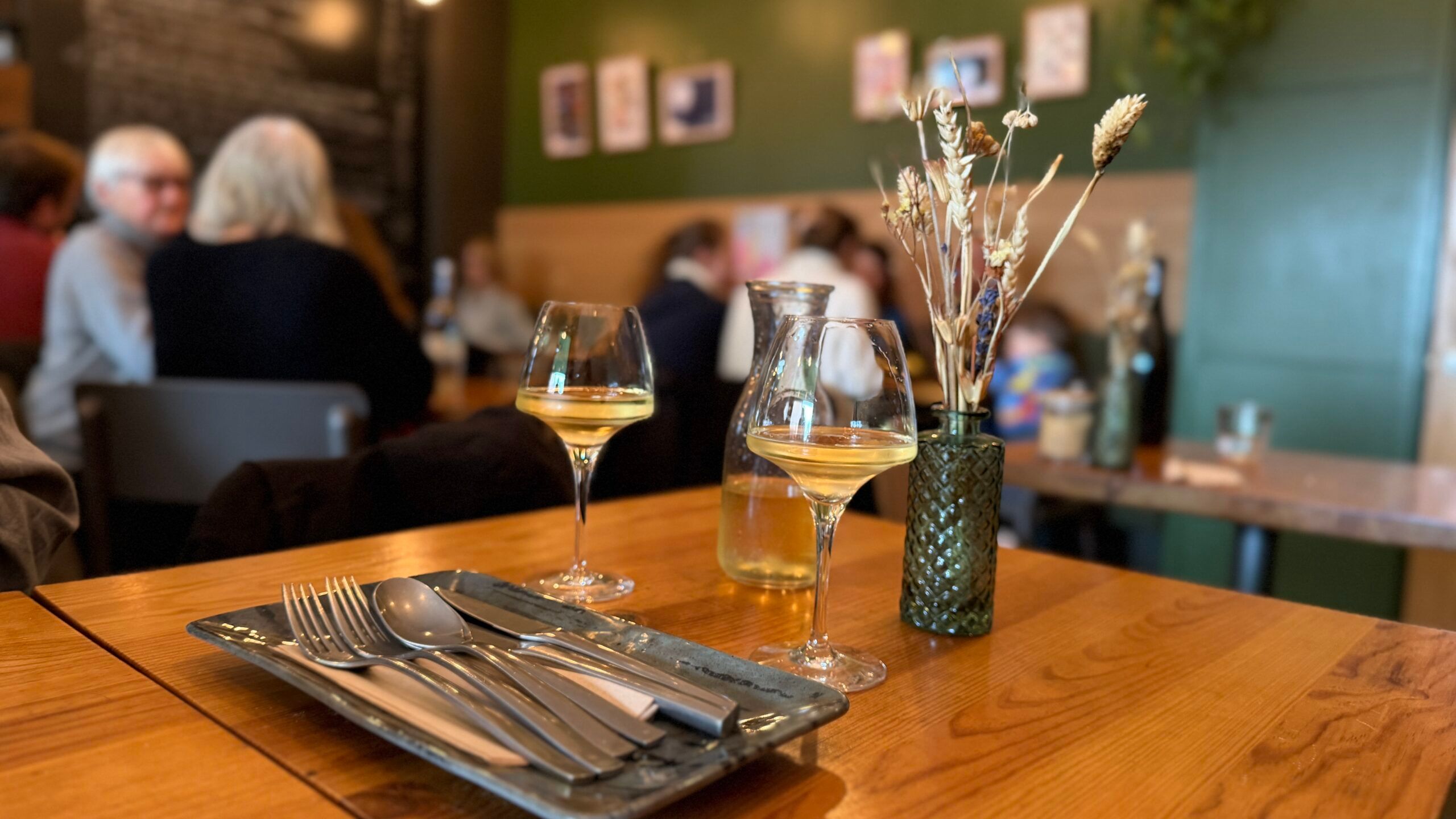 two glasses of white wine served on wooden table at Mange Tout