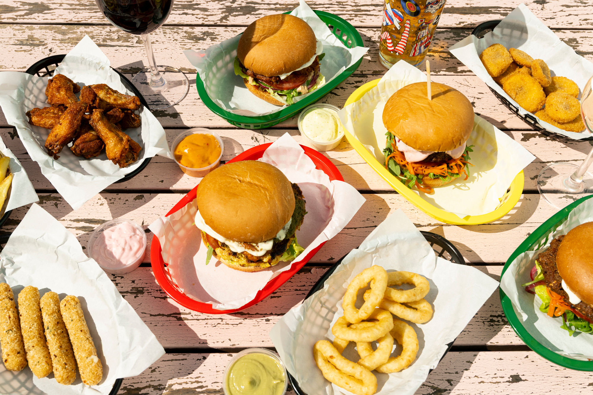 over head shot of the few burgers on the table with onion rings as sides