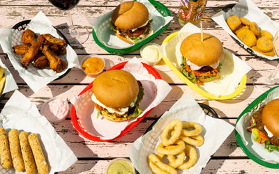 over head shot of the few burgers on the table with onion rings as sides
