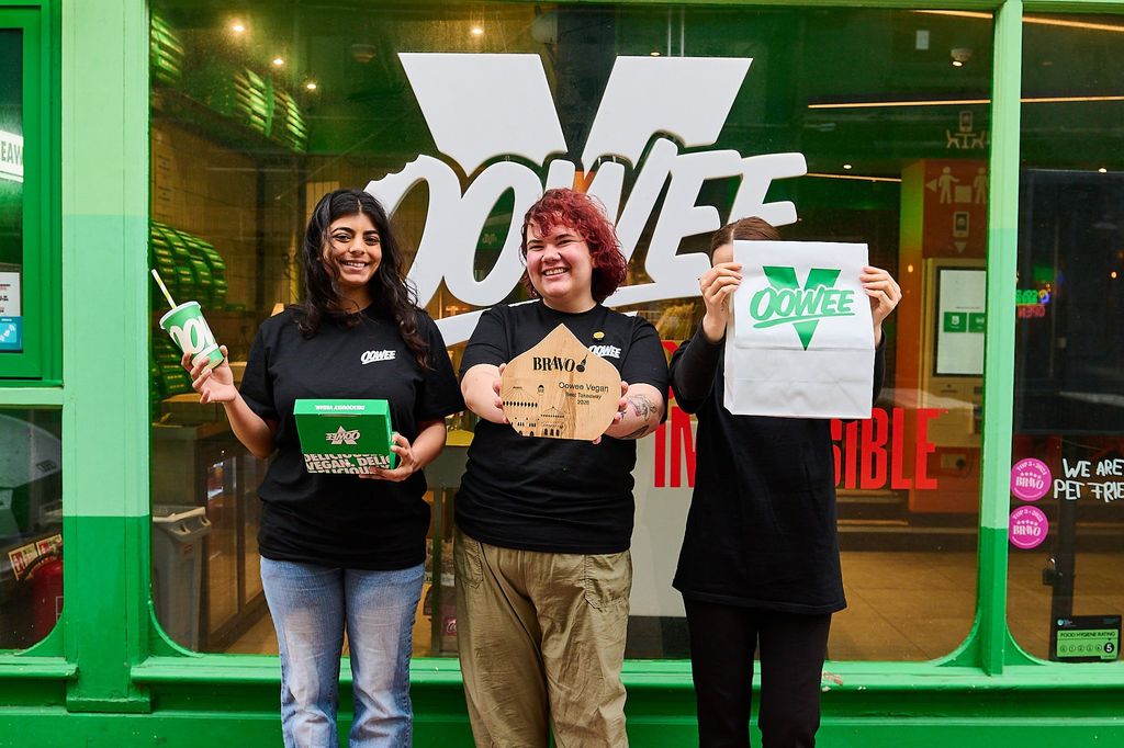 Oowee Vegan. Voted best takeaway in Brighton in 2026. Green facade of teh venue in the Lanes, with 3 staff members