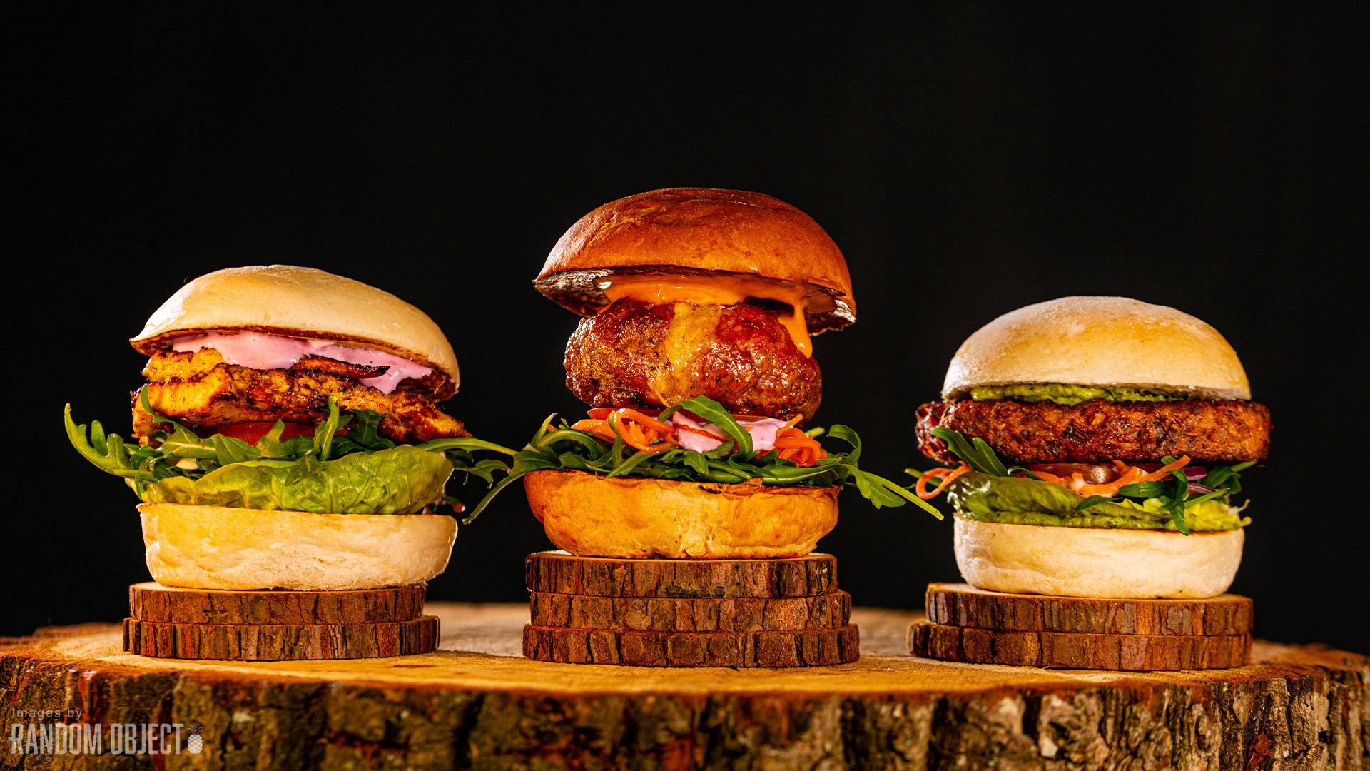 three burgers next to each other on wooden board