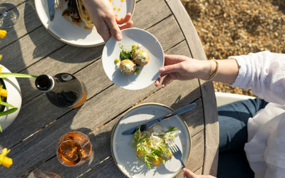 over head shot of the few dishes served on white plates on on round table at Artelium Wine Kitchen