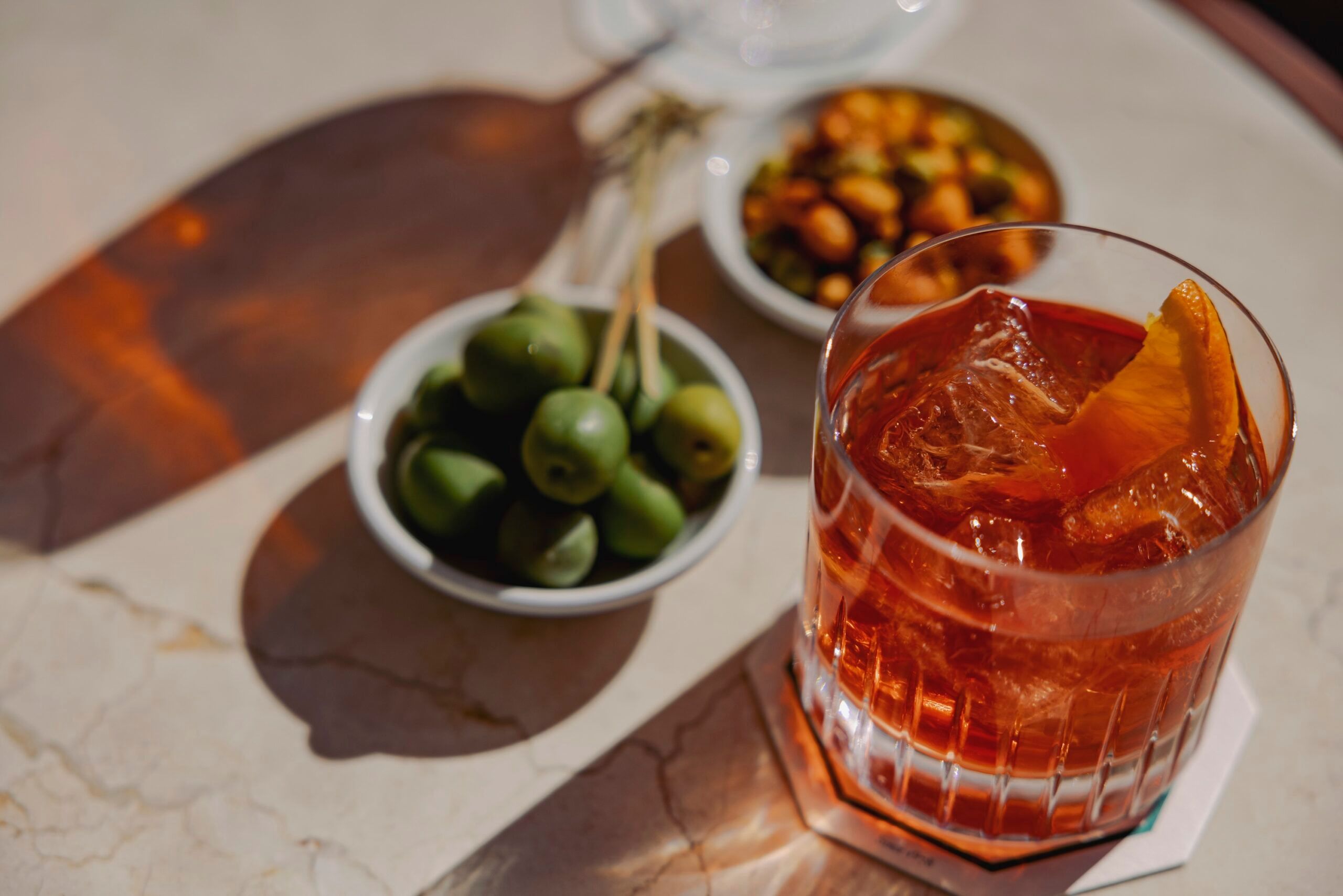 The Negroni, served on Brighton seafront. Bowl of olives and snacks nearby