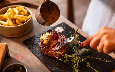 pouring gravy onto steak at Kindling