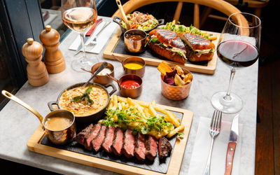 table lade out with two lunch platters served including one with steak, sides and sauces and one with burger.