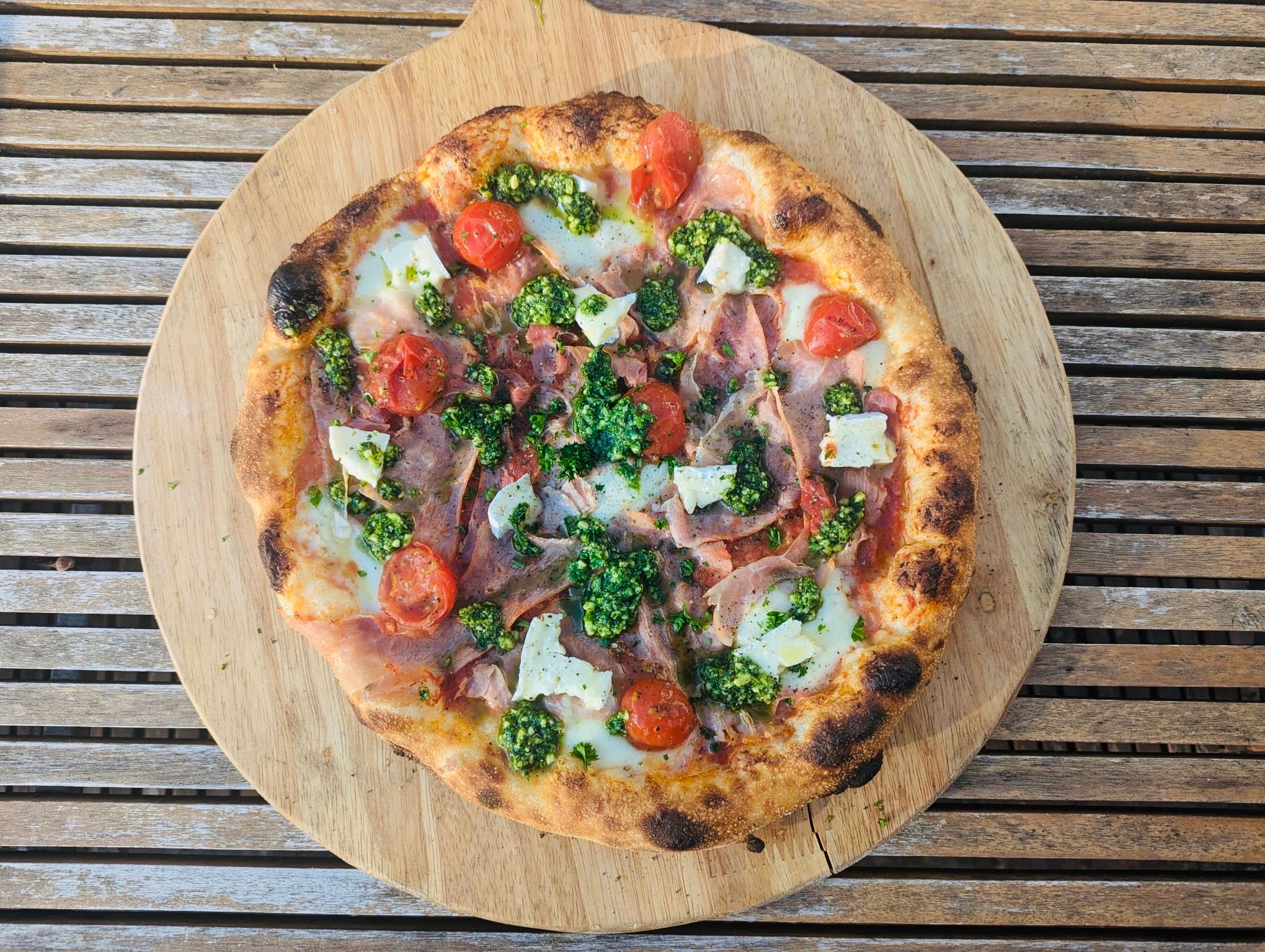 Pizza on a wooden backdrop. Artisan wood fired pizza at Wild Flour Pizza in Ovingdean