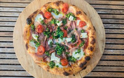 Pizza on a wooden backdrop. Artisan wood fired pizza at Wild Flour Pizza in Ovingdean