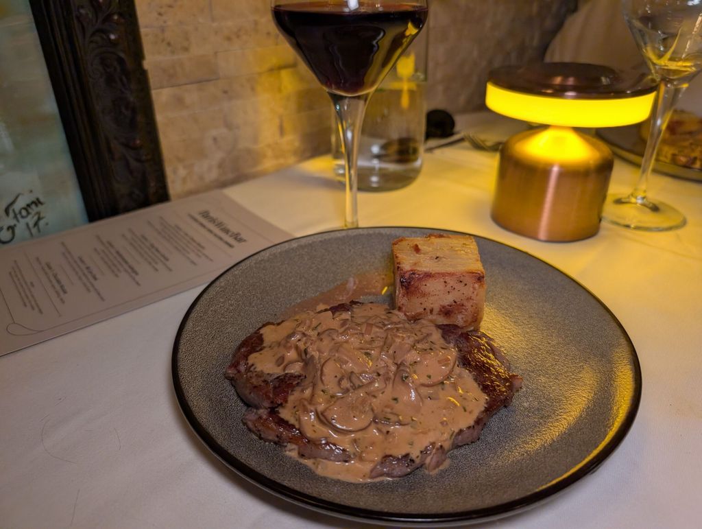 medium-rare rib-eye steak, served with dauphinoise potatoes and a classic Diane sauce