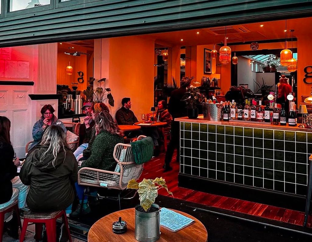 The interior in the evening with ambient light and people dining at The Greenhouse in Hove.