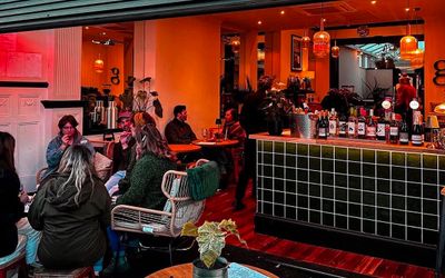 The interior in the evening with ambient light and people dining at The Greenhouse in Hove.