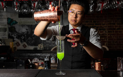 bartender preparing green cocktail at Bohemia