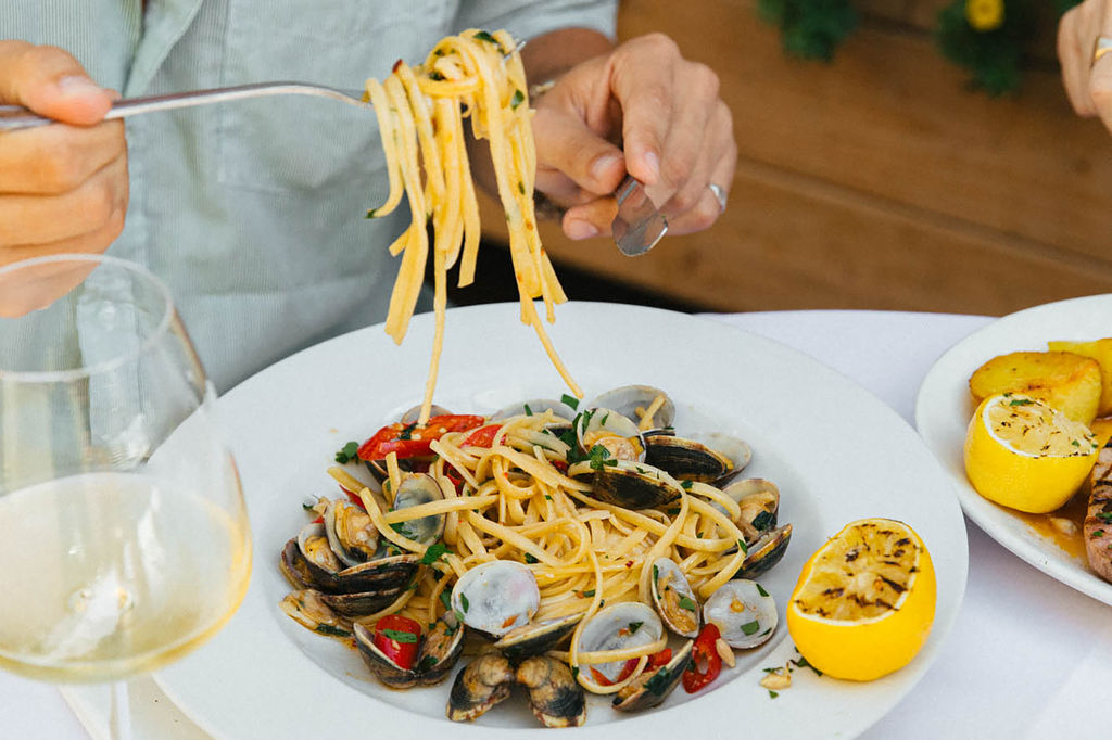 Close up of spaghetti seafood dish with half a lemon on the side of the plate