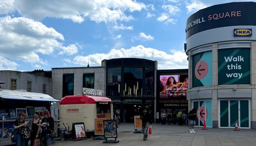People eating outside Churchill Square Shopping centre. One of the main shopping areas in Brighton