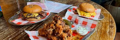 two burgers and chicken tenders on the table