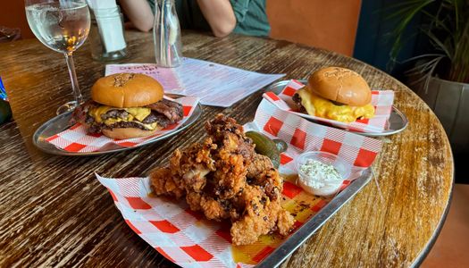 two burgers and chicken tenders on the table