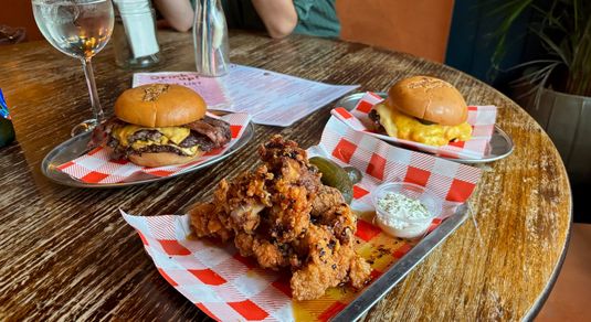 two burgers and chicken tenders on the table