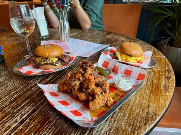 two burgers and chicken tenders on the table