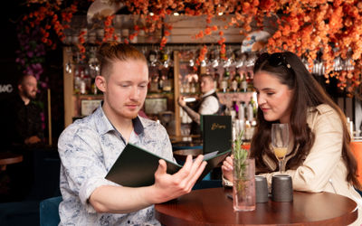 A couple looking at a menu together at Blossoms Cocktail Bar in Brighton