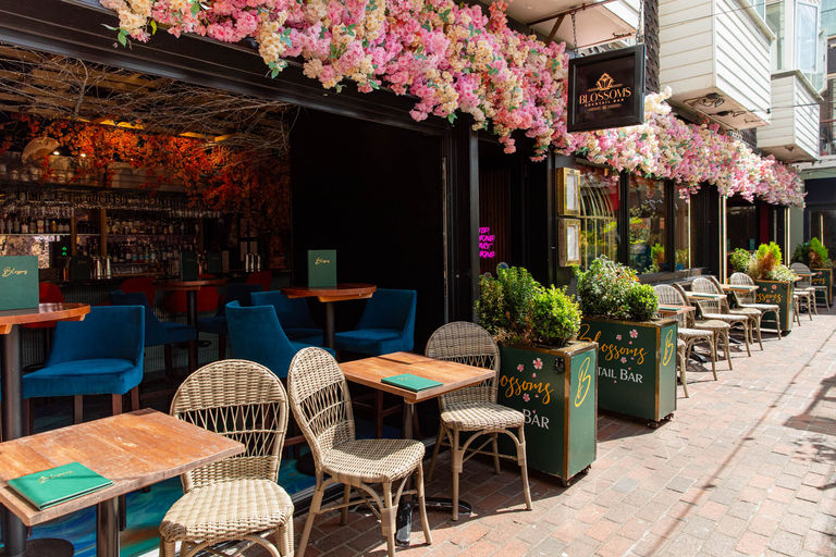 Exterior of Blossoms Cocktail Bar in Brighton on a sunny summer day with alfresco seating.