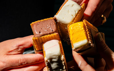 Hands holding different flavoured ice cream sandwiches at Dishoom Permit Room Brighton